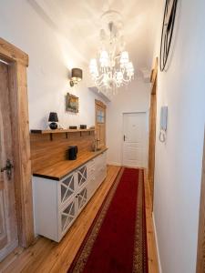 a kitchen with a chandelier and a red rug at Belle Époque Sopot in Sopot