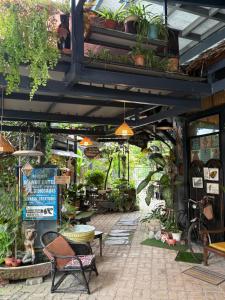 a patio with a lot of plants and chairs at Art Villa in Alor Setar