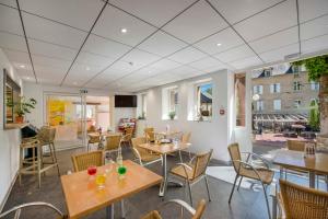 a restaurant with tables and chairs in a room at Village Vacances L'Oustal in Salles-la-Source