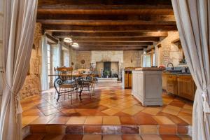 a large kitchen with a table and chairs at Maison Les Rocailles in Saint-Martin-des-Combes