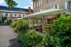 a garden with a greenhouse in front of a building at Village Vacances L'Oustal in Salles-la-Source
