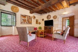 a living room with a table and chairs and a television at Maison Les Rocailles in Saint-Martin-des-Combes