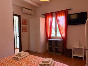 a bedroom with a bed and a television and a window at Casa Mare Holiday Pozzallo in Pozzallo