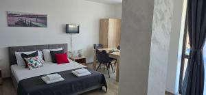 a bedroom with a bed and a table with a desk at Casa Del Mar in Primorsko