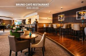a restaurant with tables and chairs and a bar at Cosmopolitan Bobycentrum - Czech Leading Hotels in Brno