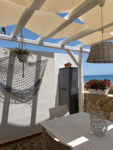 a patio with a table and a refrigerator at Casa Mare Holiday Pozzallo in Pozzallo