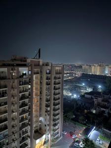 a tall apartment building at night with a city at Flippy Escapes in Zirakpur
