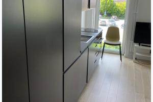 a kitchen with a refrigerator and a table and a chair at Studio Sleeps 2 Sollentuna centre in Sollentuna