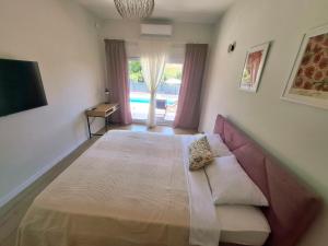a bedroom with a bed with a couch and a window at Villa Velaris Mostar in Mostar +23 photos