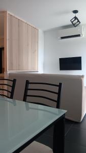 a kitchen with a glass table and two chairs at Areos de Cabío in A Pobra do Caramiñal