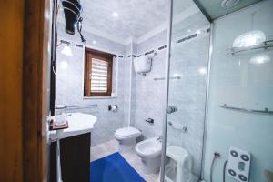 a bathroom with a shower and a toilet and a sink at Hotel Lo Scoiattolo in Cotronei