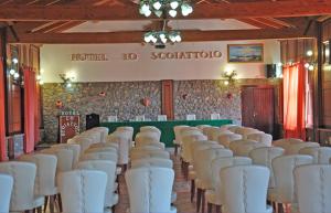 a row of white chairs in a room with a wall at Hotel Lo Scoiattolo in Cotronei