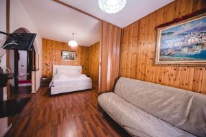 a living room with a couch and a bed at Hotel Lo Scoiattolo in Cotronei