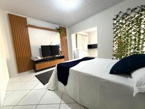 a bedroom with a bed and a flat screen tv at Suíte premium Ar , WI-FI e TV SMART in Rondonópolis