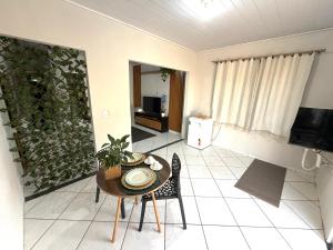 a living room with a table and chairs and a television at Suíte premium Ar , WI-FI e TV SMART in Rondonópolis