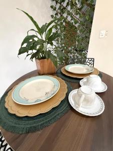 a wooden table with plates and dishes on it at Suíte premium Ar , WI-FI e TV SMART in Rondonópolis