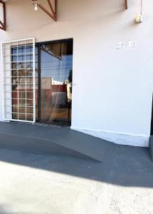 a glass door of a building with a window at Suíte premium Ar , WI-FI e TV SMART in Rondonópolis