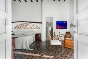 a bedroom with a bed and a table and a chair at Boutique Hotel I Cinque Balconi in Santa Marina Salina