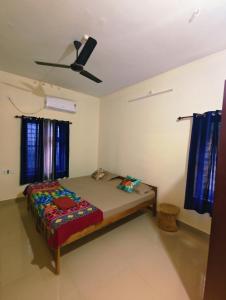 a bedroom with a bed and a ceiling fan at Phoenix homestay in Varkala