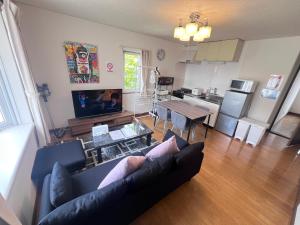 a living room with a couch and a table and a kitchen at Transys three in Chitose
