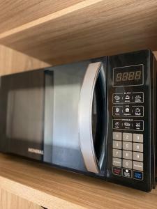 a microwave oven sitting on top of a shelf at Aconchego Perto das praias da região oceânica in Niterói
