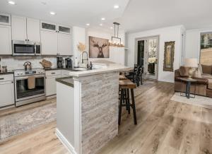 an open kitchen and living room with white cabinets at Highlands Slopeside in Beaver Creek