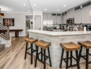 a kitchen with wooden stools at a counter at Highlands Slopeside in Beaver Creek