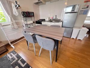 a kitchen with a wooden table and two chairs at Transys three in Chitose