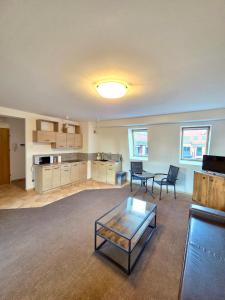 a living room with a coffee table and a kitchen at Justinrent Szpitalna 4D-5 in Legnica