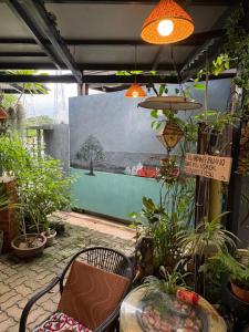 a patio with plants and a bench and a painting at Art Villa in Alor Setar
