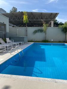 a blue swimming pool with two chairs next to a building at Aconchego Perto das praias da região oceânica in Niterói
