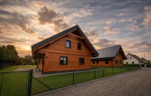 a wooden house with a fence in front of it at Chalupa Nicol in Vítějeves