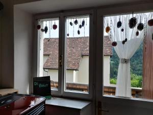 a kitchen with a window with a curtain at Di Baut in Ovaro