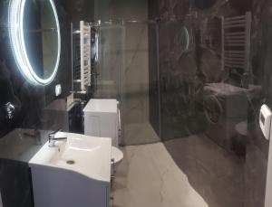 a bathroom with a sink and a mirror and a toilet at Apartamenty AGA13 in Mikołajki +33 photos