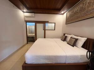 a bedroom with a large white bed in a room at Arsa Wayan Guest House in Klungkung