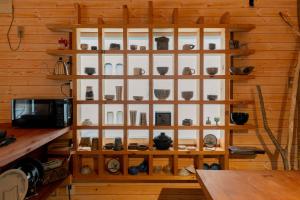 a room with a wooden wall with shelves of pottery at Kussharoko Artemina Lotus in Teshikaga