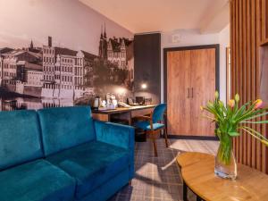 a living room with a blue couch and a table at Mercure Opole in Opole