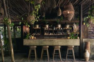 a bar in a restaurant with stools and pots at BE Destination Tulum in Tulum