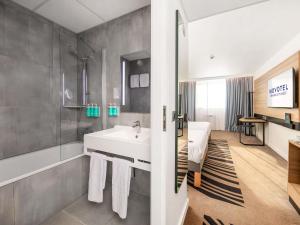 a bathroom with a white sink and a shower at Novotel Kraków City West in Krakow