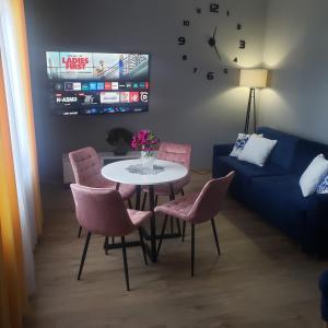 a living room with a table and chairs and a couch at Apartamenty AGA13 in Mikołajki