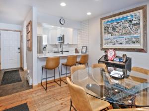 a kitchen and dining room with a glass table and chairs at Ptarmigan Townhomes 30 in Vail
