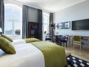 a hotel room with two beds and a dining room at Sofitel Grand Sopot in Sopot