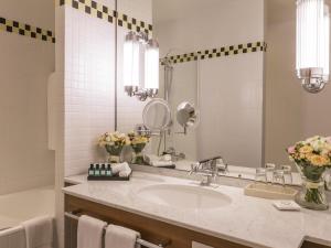 a bathroom with a sink and a mirror at Sofitel Grand Sopot in Sopot +104 photos