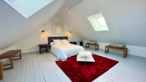 a bedroom with a bed and a red rug at Le Quai Granvillais in Granville