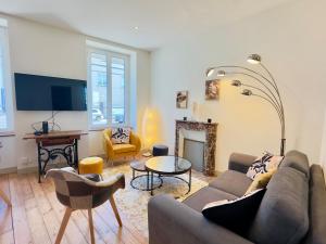 a living room with a couch and a fireplace at Le Quai Granvillais in Granville