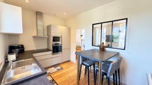 a kitchen with a table and chairs in a room at Le Quai Granvillais in Granville
