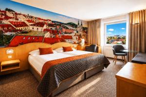 a hotel room with a large bed and a city mural at Cosmopolitan Bobycentrum - Czech Leading Hotels in Brno
