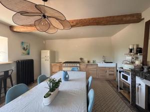 a kitchen with a table and a ceiling fan at Clos Lavaux in Châtenay