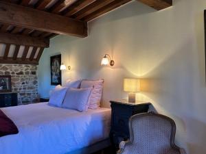 a bedroom with a bed with a lamp and a chair at Clos Lavaux in Châtenay
