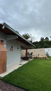 a house with a yard with green grass at Chácara encantos Iranduba in Iranduba